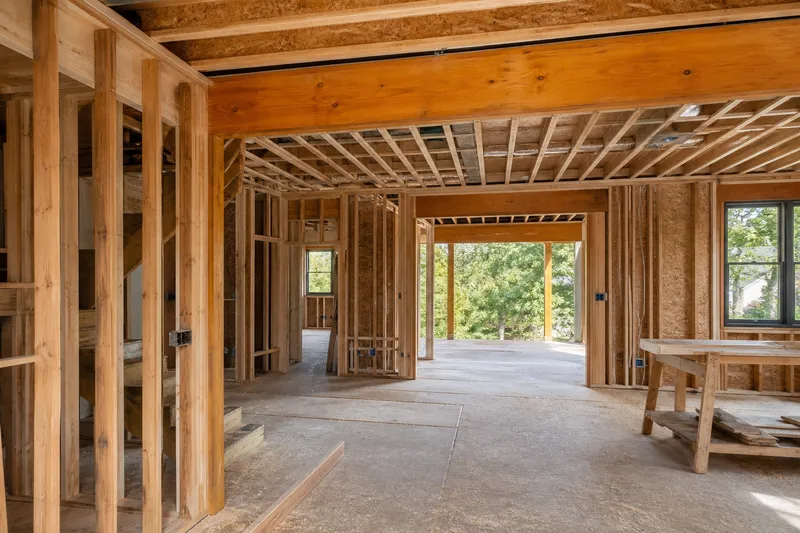 Residential construction interior with exposed framing and structural wood beams